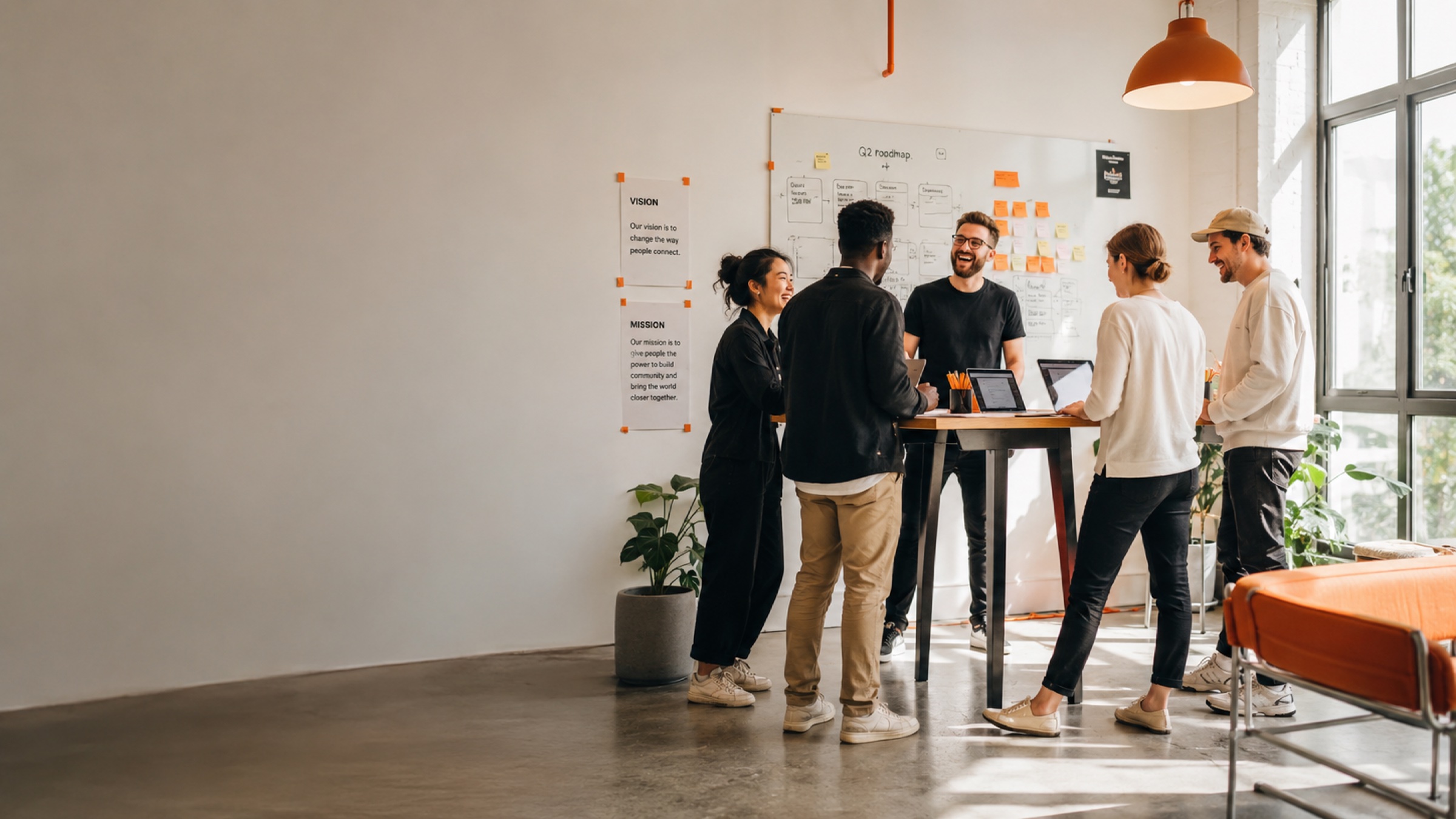 Une petite équipe produit qui collabore à un bureau debout devant un tableau blanc
