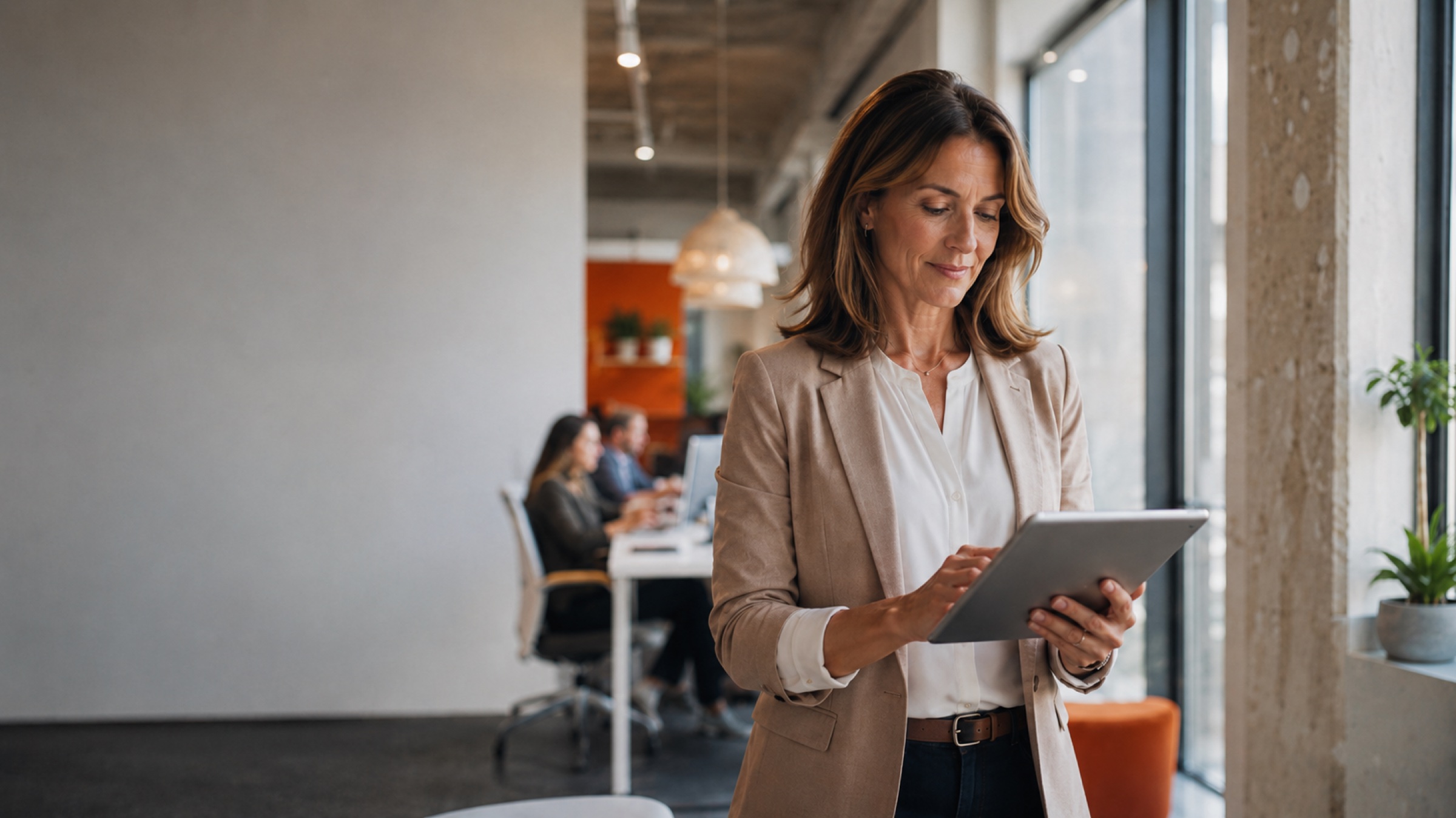 Um líder de pessoas revisando insights em um tablet em um escritório moderno